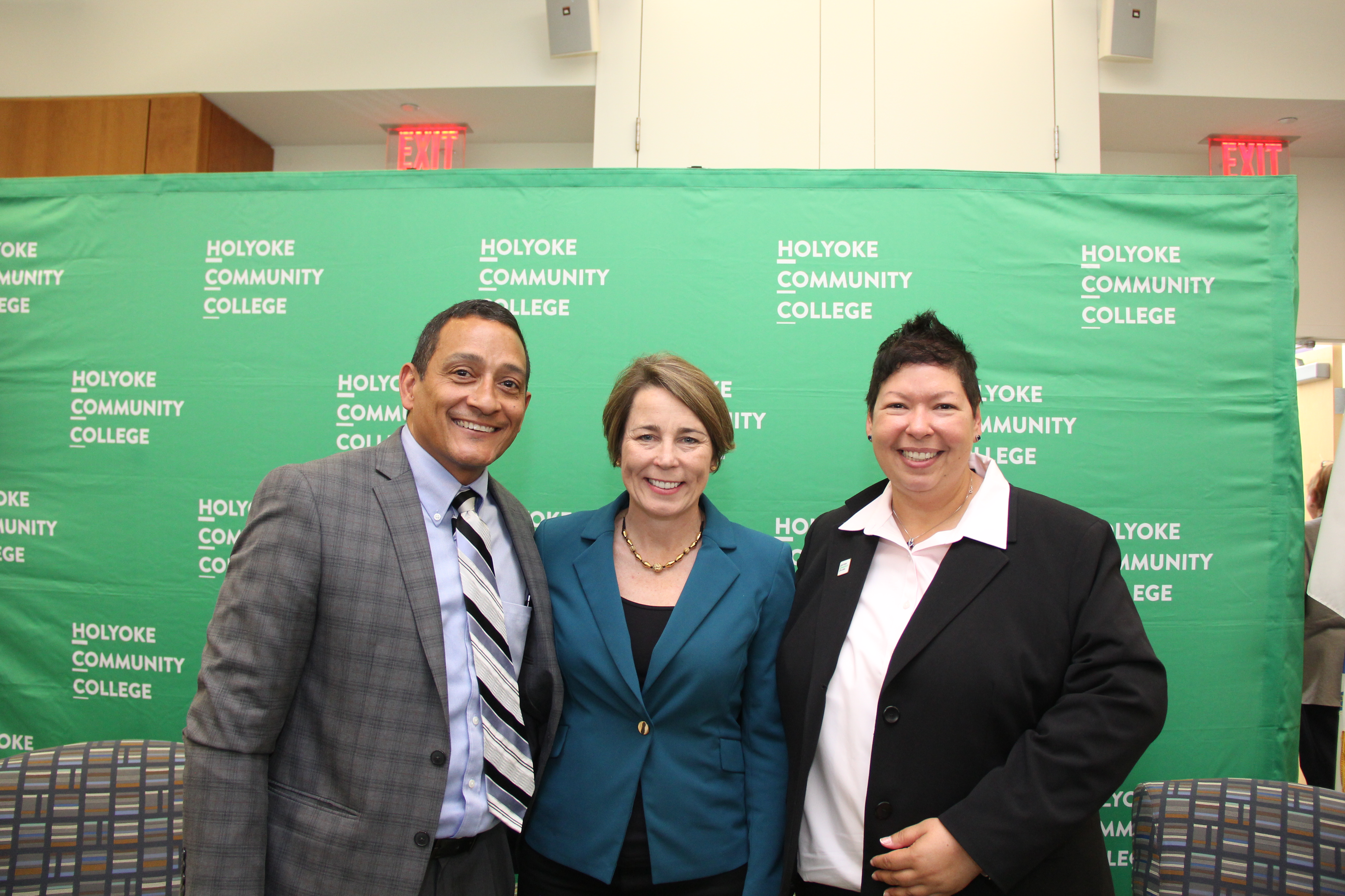 Christina Royal poses with criminal justice professor Alex Sanchez and MA governor Maura Healey
